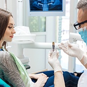 A dentist talking to a patient about how dental implants work