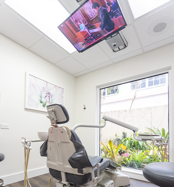 Dental treatment room with a television mounted on the ceiling