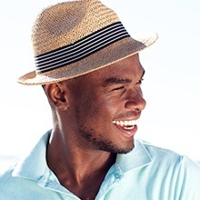 Man with a sun hat smiling after cosmetic dentistry