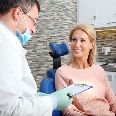 Woman in dental chair listening to her dentist talk