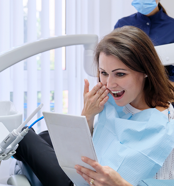 Dental patient admiring her smile in a mirror