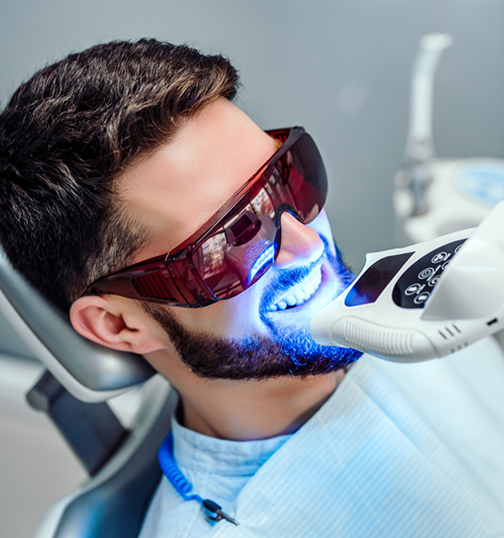 Man in dental chair getting his teeth professionally whitened