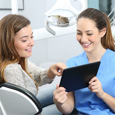 Dental team member showing a tablet screen to a patient