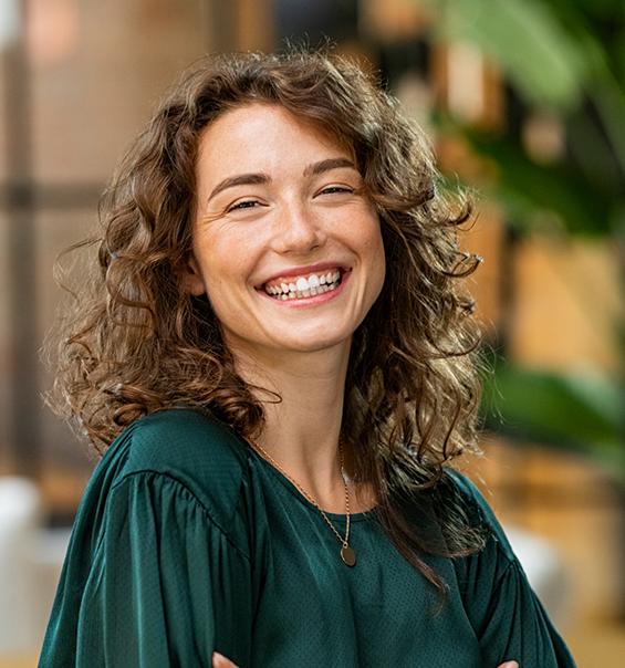 Woman with curly brown hair grinning