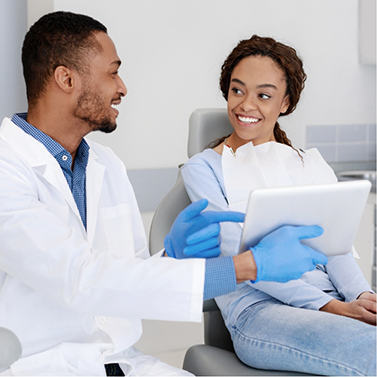 Dentist showing a tablet screen to a patient