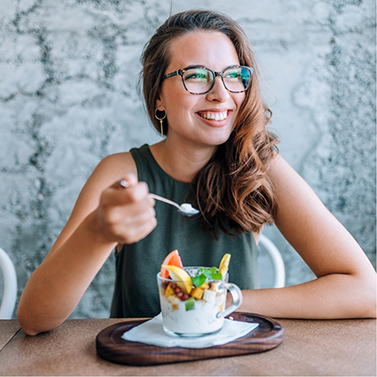 Smiling woman eating a yogurt parfait