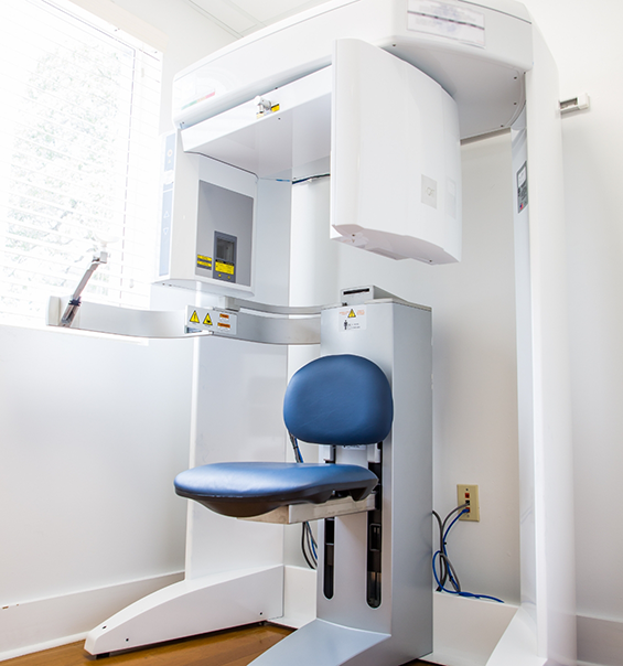 C T cone beam scanner standing against white wall in dental office