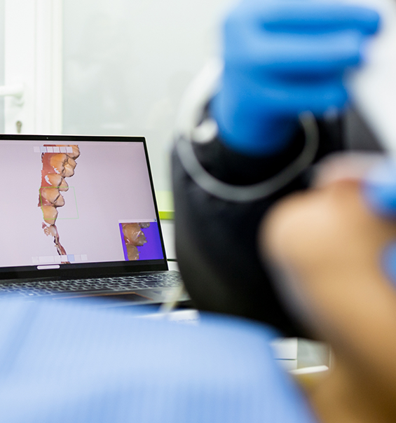 Digital impressions of teeth on a screen in a dental treatment room