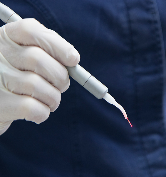 Dentist holding a pen like dental laser device