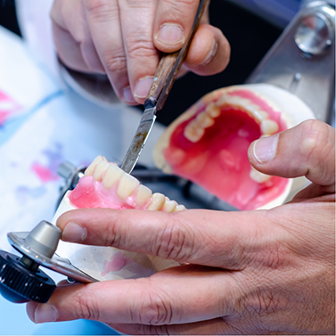 Dental professional crafting a denture