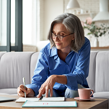 Woman filling out paperwork on her coffee table