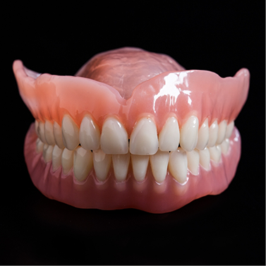 Set of full dentures against black background