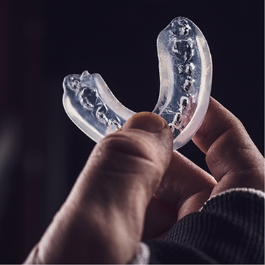 Hand holding a clear mouthguard