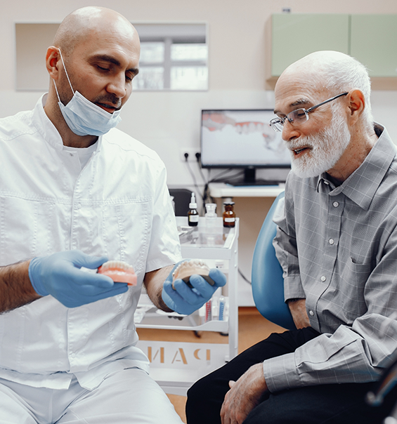 Dentist showing a denture to a patient