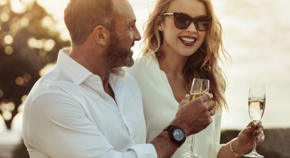 Man and woman holding champagne flutes outdoors