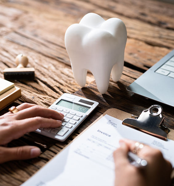 Person filling out dental insurance paperwork on a clipboard