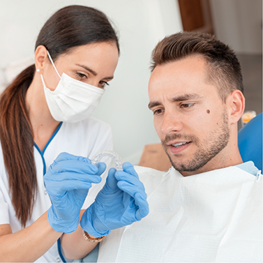 Dentist showing a clear aligner to a patient