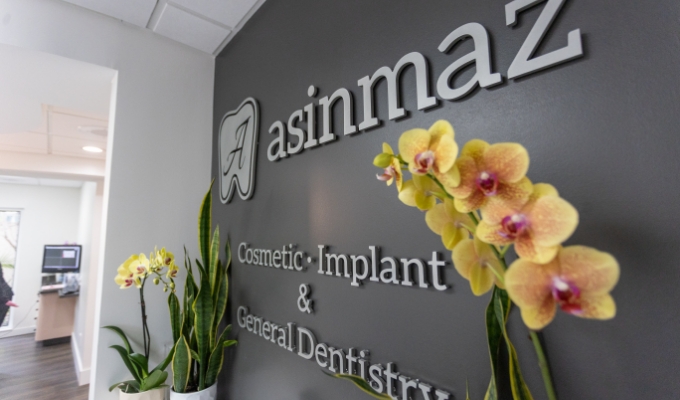 Sign on wall of dental office that reads Asinmaz Cosmetic Implant and General Dentistry