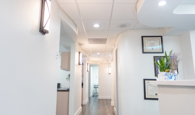 Pristine white hallway leading to dental treatment rooms