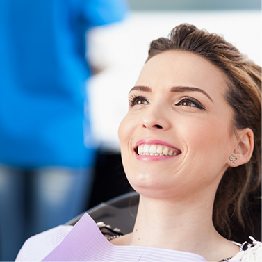 Smiling woman leaning back in dental chair