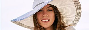 Woman with healthy smile after periodontal therapy smiling and wearing a large hat