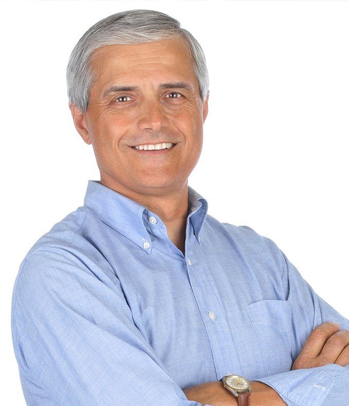 Smiling older man standing with arms crossed