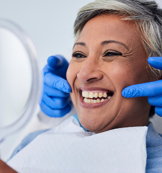 Senior woman looking at her grin in a mirror