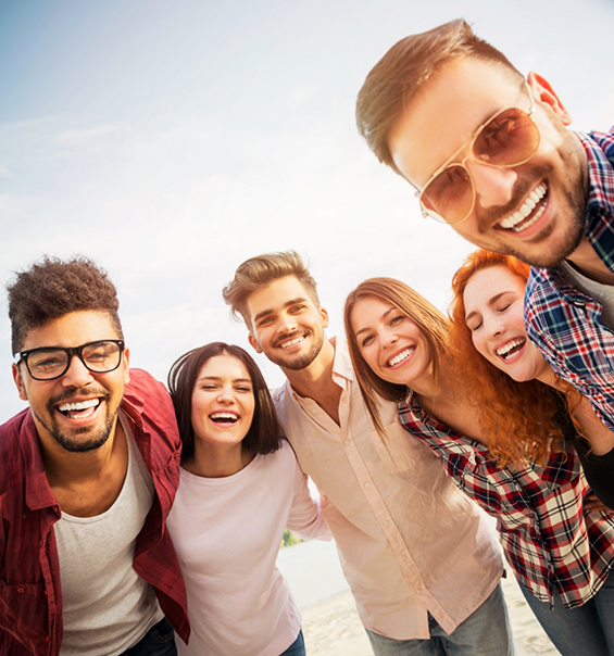 Group of adults smiling together outdoors on a sunny day