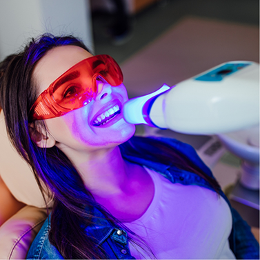 Woman in dental chair having her teeth professionally whitened