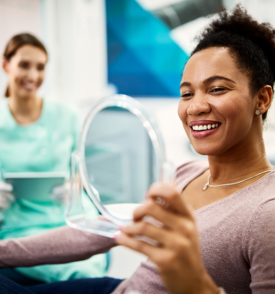 Dental patient admiring her smile in a mirror