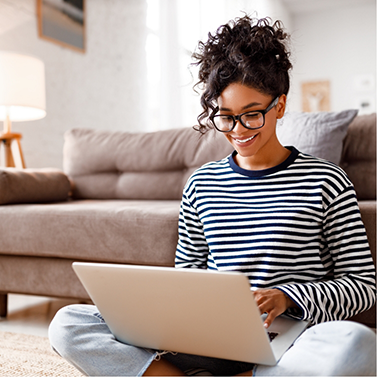 Young woman smiling while looking at laptop