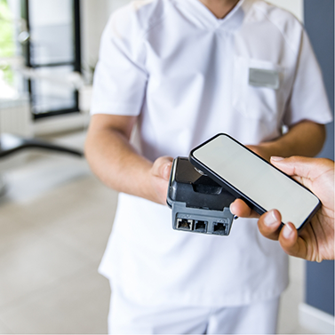 Person using their phone to pay for dental treatment