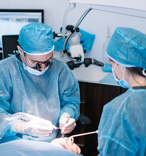 Dentist and assistant performing wisdom tooth extraction