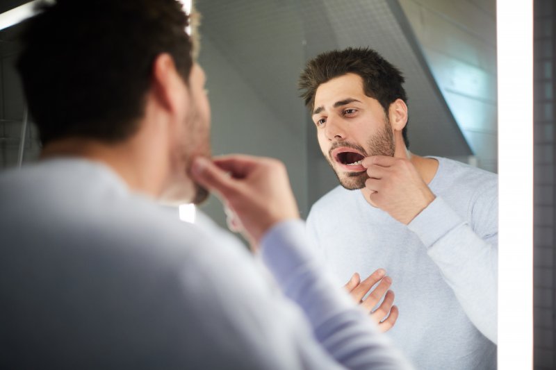 Man checking his teeth in the mirror